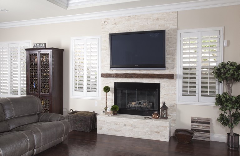 White plantation shutters in a Philadelphia living room with plank hardwood floors.